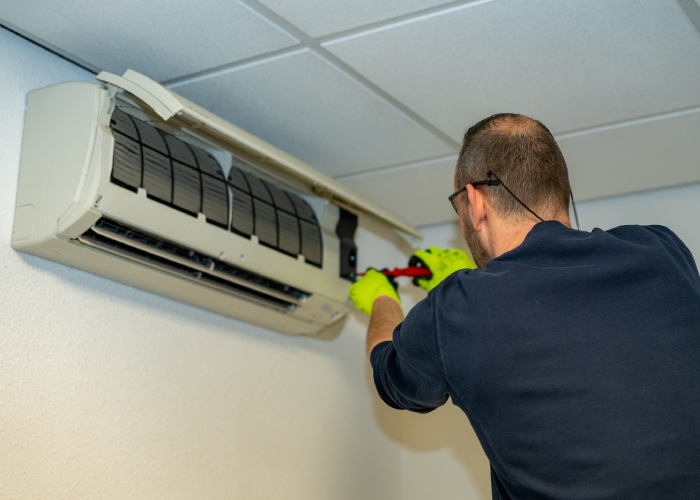 Technicus van Schoonebeek Klimaattechniek installeert airco in een woning in Eelde