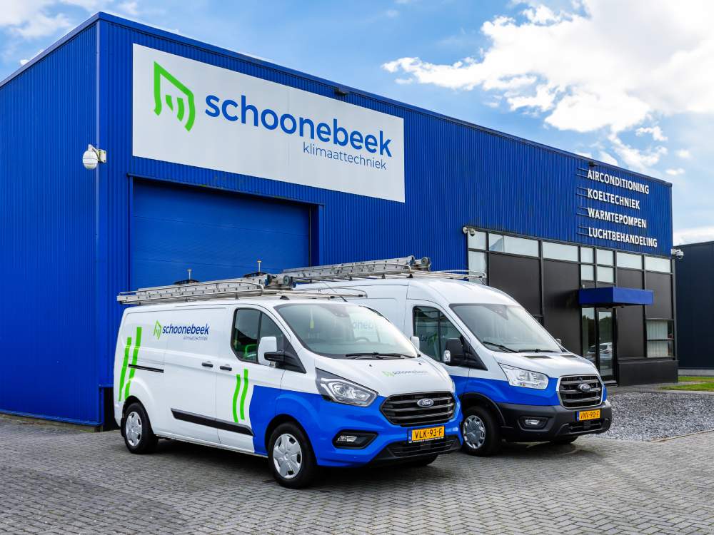 Schoonebeek Klimaattechniek bestelbusjes geparkeerd bij het bedrijfspand met blauw-witte gevel.