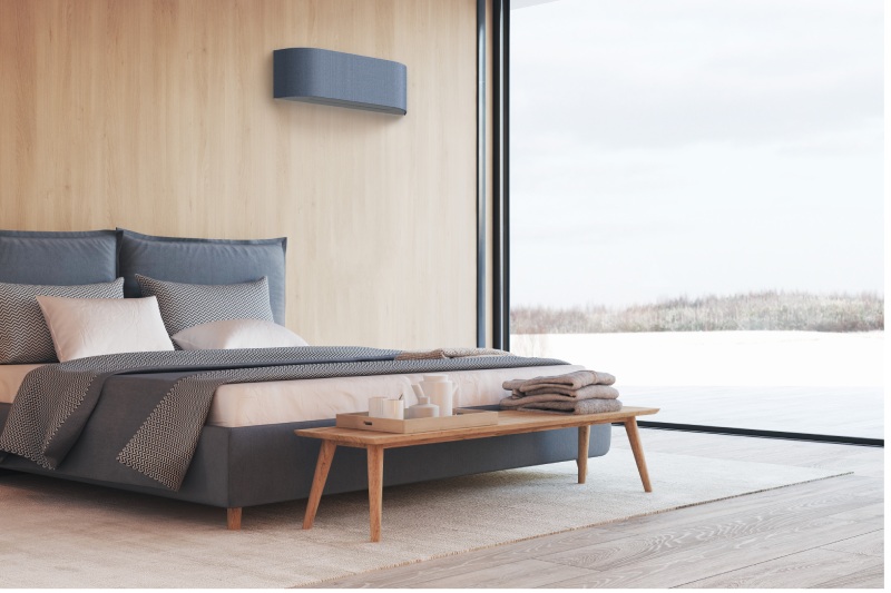 Stijlvolle slaapkamer met een opgemaakt bed en aan de muur een airco van het merk toshiba