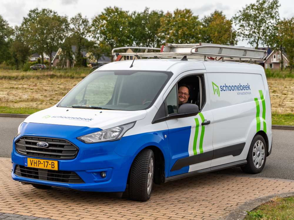Schoonebeek Klimaattechniek bedrijfswagen geparkeerd op straat, klaar voor een installatie.
